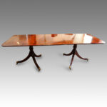 Regency style mahogany cross-banded twin pillar dining table