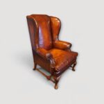 Walnut framed leather wingback chairs with carved cabriole legs