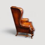 Traditional English leather wing chairs with turned stretchers